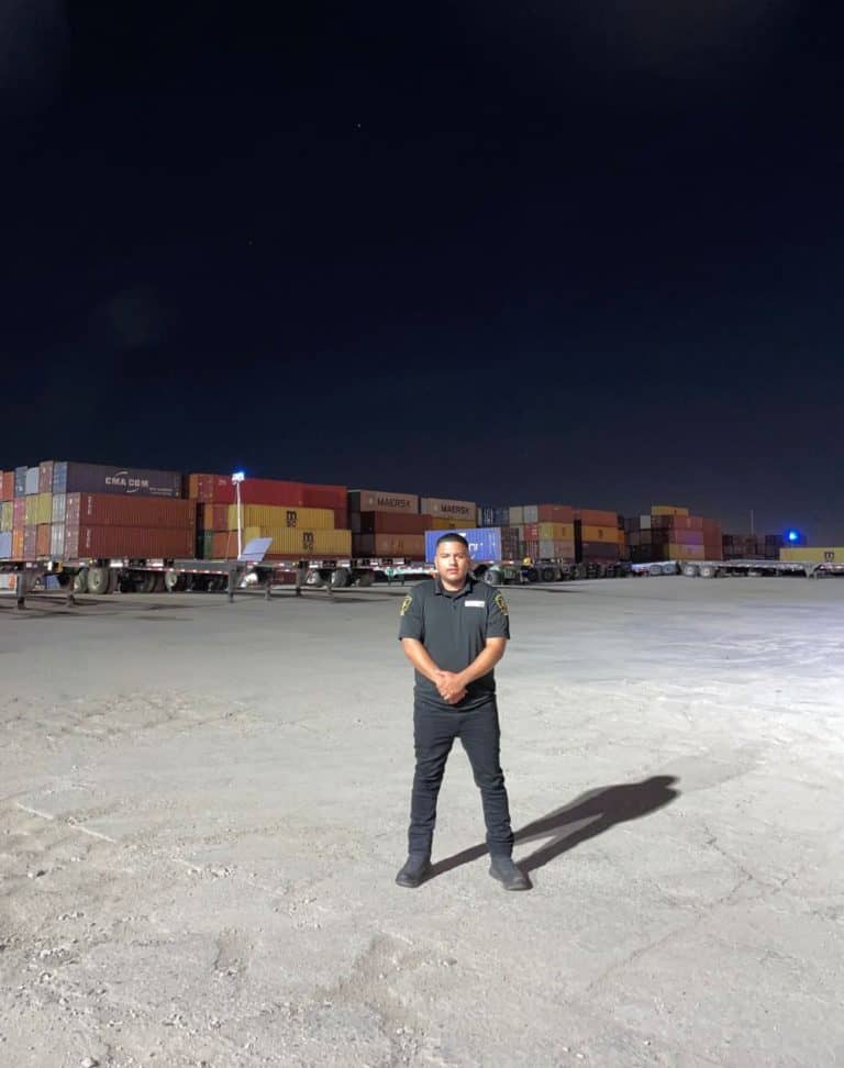 OPS security guard at a port facility standing to protect cannisters from theft. The facility is located in Long Beach, CA.